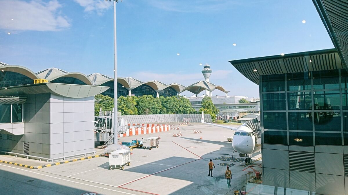 KLIA terminal, control tower and aircraft at a boarding gate